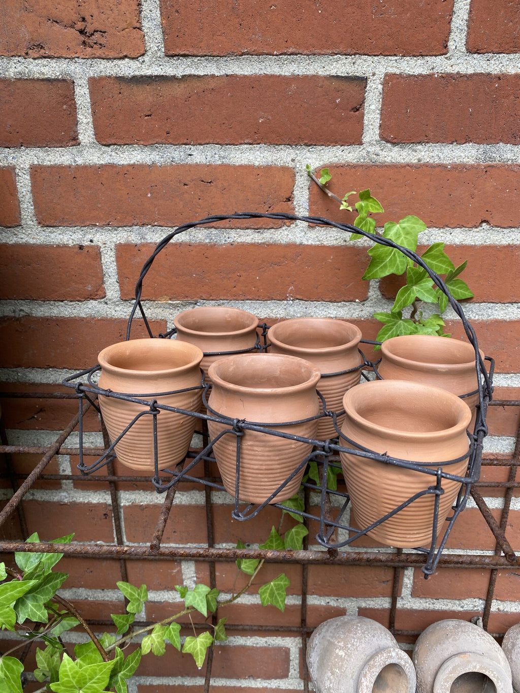 Terracotta potter med jernholder